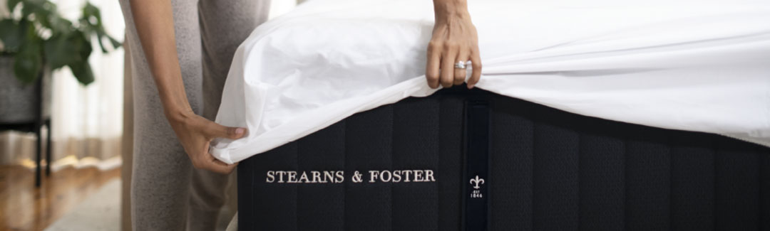 Woman putting sheets on a Stearns & Foster mattress Woman putting sheets on a Stearns & Foster mattress